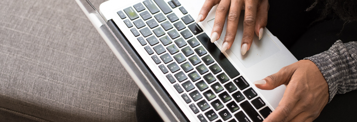 Man sieht Frauenh&auml;nde an einem Laptop.